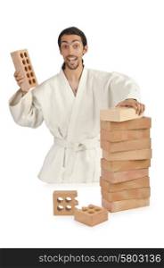 Karate man breaking bricks on white
