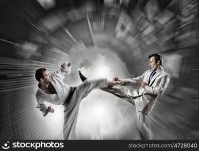 Karate man in white kimino. Young determined karate man fighting with businessman in suit