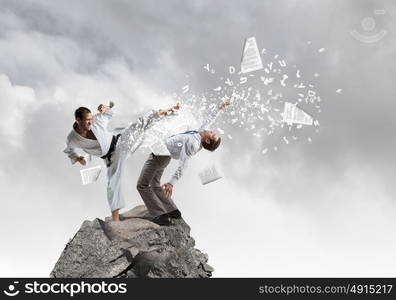 Karate man in white kimino. Young determined karate man fighting with businessman in suit