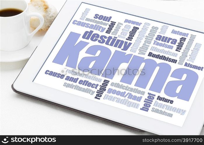 karma word cloud on a digital tablet with a cup of coffee - spiritual concept