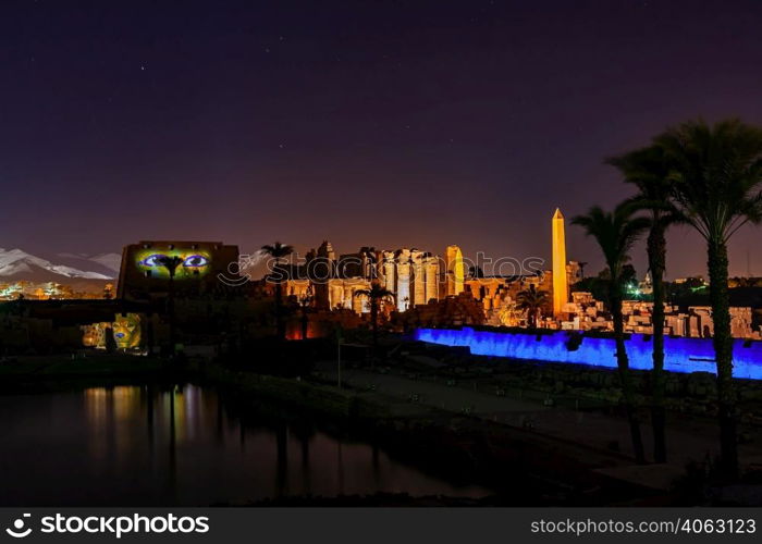 Karnak Temple Complex in the night with a high obelisk and sacred lake, Luxor, Upper Egypt.