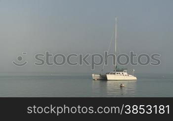 Katamaran im Morgennebel - Catamaran laying at a marina in morning fog
