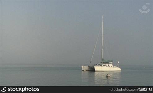 Katamaran im Morgennebel - Catamaran laying at a marina in morning fog