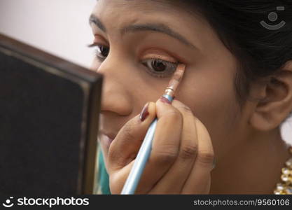 Kathak dancer applying makeup on her face. 