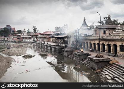 KATHMANDU - APRIL 15: Cremation ceremony along the holy Bagmati River at Pashupatinath Temple complex, April 15, 2012 in Kathmandu, Nepal. This is the most sacred place to all Hindus in Nepal.