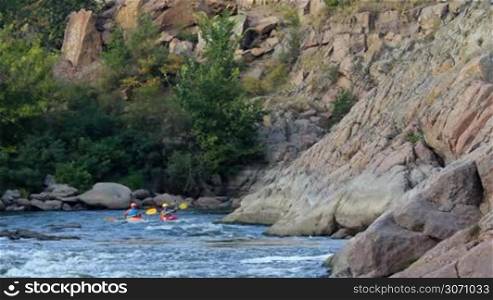 kayak rowers train pass rapids on the river