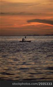 Kayaker outdoors in ocean at sunset (far away/silhouette)