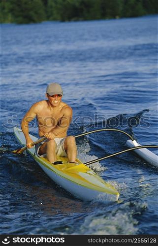 Kayaker rowing in calm waters (selective focus)
