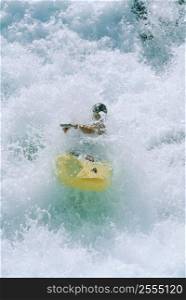 Kayaker rowing in rapids
