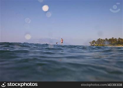 Kayaker rowing in sea