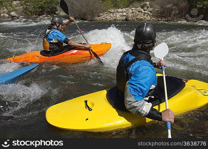 Kayakers on river, side view