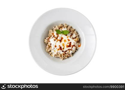 Kayseri ravioli or Kayseri Mantisi on a white plate on white background