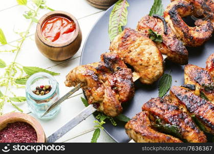 Kebab on skewers with nettle marinade.Meat on skewers,barbecue. Kebab marinated in nettles