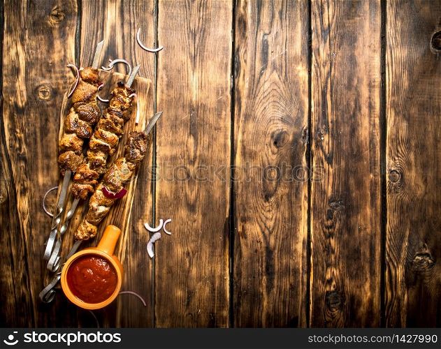 Kebab with tomato sauce. On wooden background.. Kebab with tomato sauce.