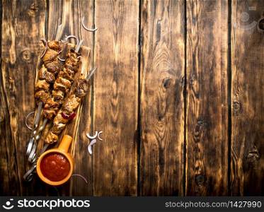 Kebab with tomato sauce. On wooden background.. Kebab with tomato sauce.