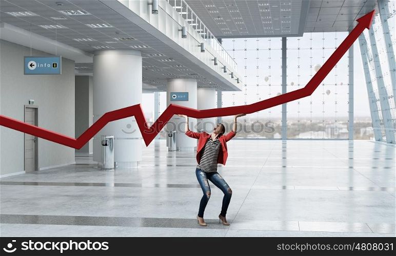 Keep income rising. Young woman in modern interior making red arrow grow