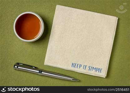 keep it simple inspirational note - handwriting on a a napkin with a copy space, flat lay with tea, simplicity, minimalism or lifestyle concept