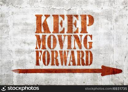 Keep moving forward - red graffiti sign with arrow on a white stucco wall