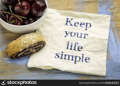 Keep your life simple advice or reminder - handwriting on a napkin with cherries and cookie