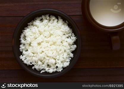 Kefir grains in bowl and a cup of milk on the side, photographed overhead with natural light (Selective Focus, Focus on the kefir grains). Kefir Grains