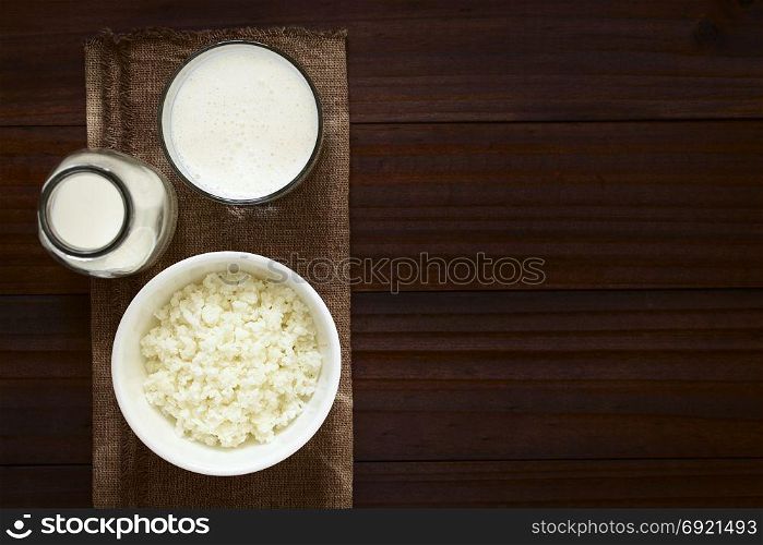 Kefir grains in bowl, fresh kefir drink in glass and a bottle of milk, photographed overhead with natural light (Selective Focus, Focus on the kefir grains and the kefir drink). Kefir