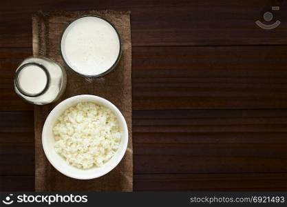 Kefir grains in bowl, fresh kefir drink in glass and a bottle of milk, photographed overhead with natural light (Selective Focus, Focus on the kefir grains and the kefir drink). Kefir