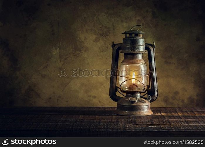 kerosene lamp oil lantern burning with glow soft light on aged wood floor.
