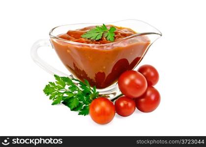 Ketchup in a glass gravy boat with tomatoes and parsley isolated on white background