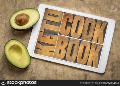 keto cookbook word abstract in letterpress wood type on a digital tablet with avocado, healthy diet and eating concept