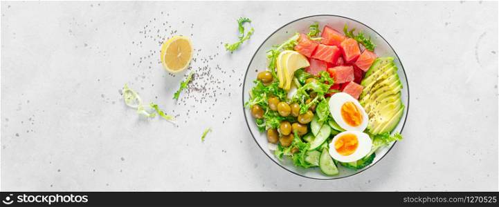 Ketogenic, keto or paleo diet lunch bowl with salted salmon fish, lemon, avocado, olives, boiled egg, cucumber, green lettuce salad and chia seeds. Healthy food trend. Top view. Banner