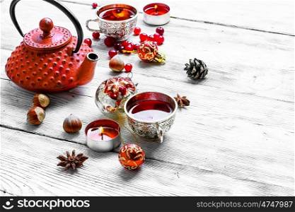 Kettle,cranberry tea and Christmas toy on light background