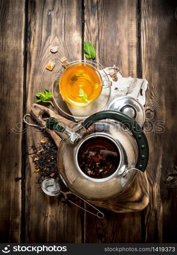 Kettle with fragrant floral tea. On wooden background.. Kettle with fragrant floral tea.