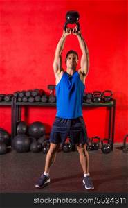 Kettlebell swing workout training man at gym with red walls
