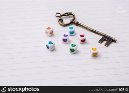 Key and colorful cubes with a heart placed on paper