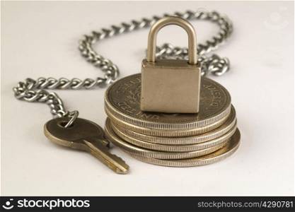 key and padlock on coins
