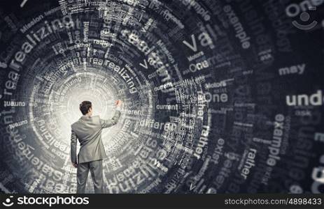 Key concepts to your success. Back view of businessman writing leadership concepts on wall