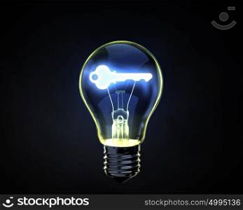 Key idea. Light bulb with key inside on dark background
