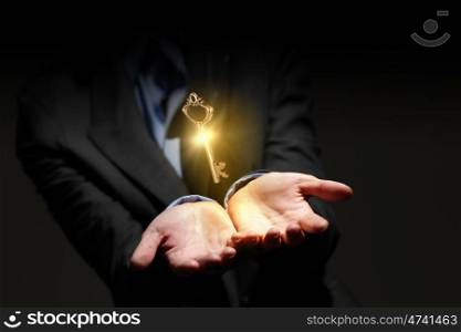 Key in hand. Close up image of business person holding shining key