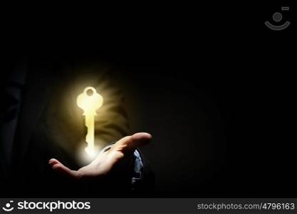 Key in hand. Close up image of business person holding shining key