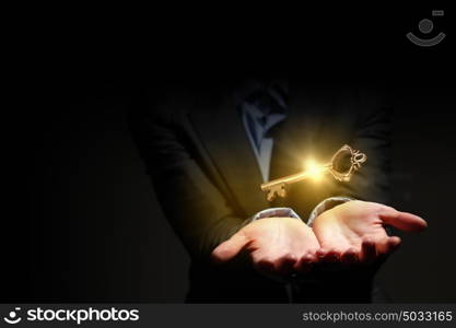 Key in hand. Close up image of business person holding shining key