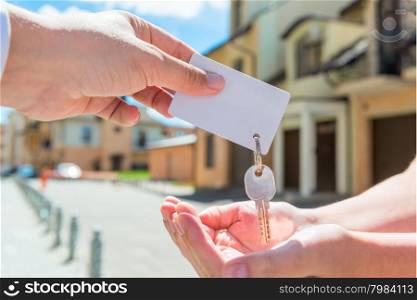 key of apartment and a card for an inscription in the hands of people
