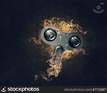 Key sign in fire flames. Key as security or success symbol burning in fire on dark background