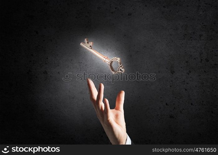 Key symbol in hand. Close up of businessman hand showing key to success