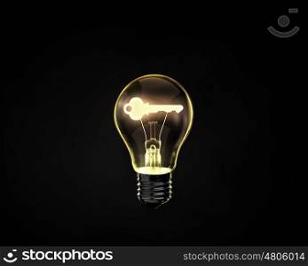 Key to creativity. Light bulb with key inside on dark background
