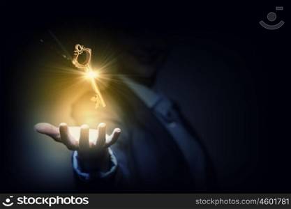 Key to success. Close up of businesswoman holding golden key in hand
