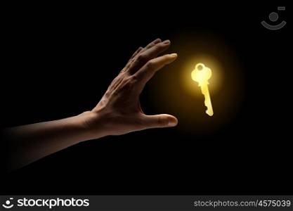 Key to success. Close up of human hand catching golden key
