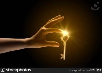 Key to success. Close up of human hand catching golden key