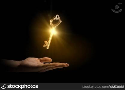 Key to success. Close up of human hand holding golden key