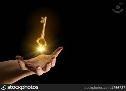 Key to success. Close up of human hand holding golden key