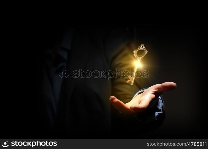 Key to success. Close up of human hand holding golden key